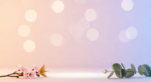 Branch with pink flowers and green leaves on a white surface Background Image