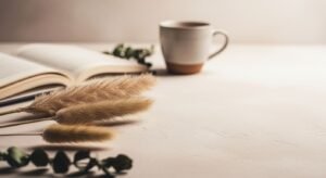 Cup of coffee and a book on a table Background Image