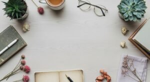 Desk with a cup of coffee, books and flowers on it Background Image
