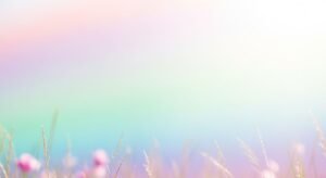 Field of grass with pink flowers in the foreground Background Image