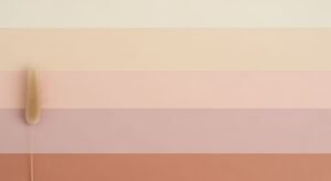Pink and beige striped wall with a feather on it Background Image