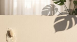 White feather hanging on a wall next to a plant Background Image